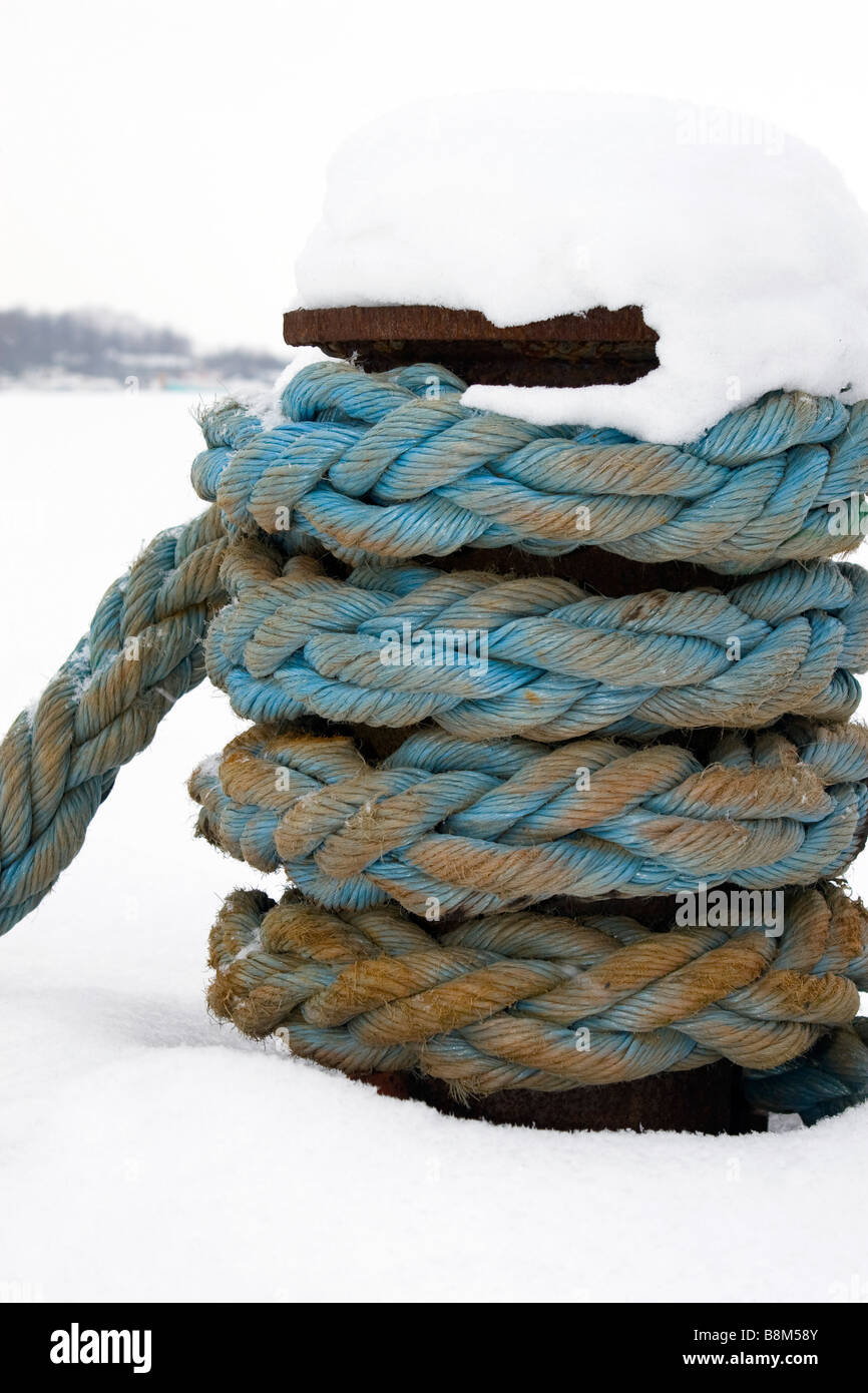 Unico bollard sul molo con cavo di traino fissata nel fuori stagione invernale. Foto Stock