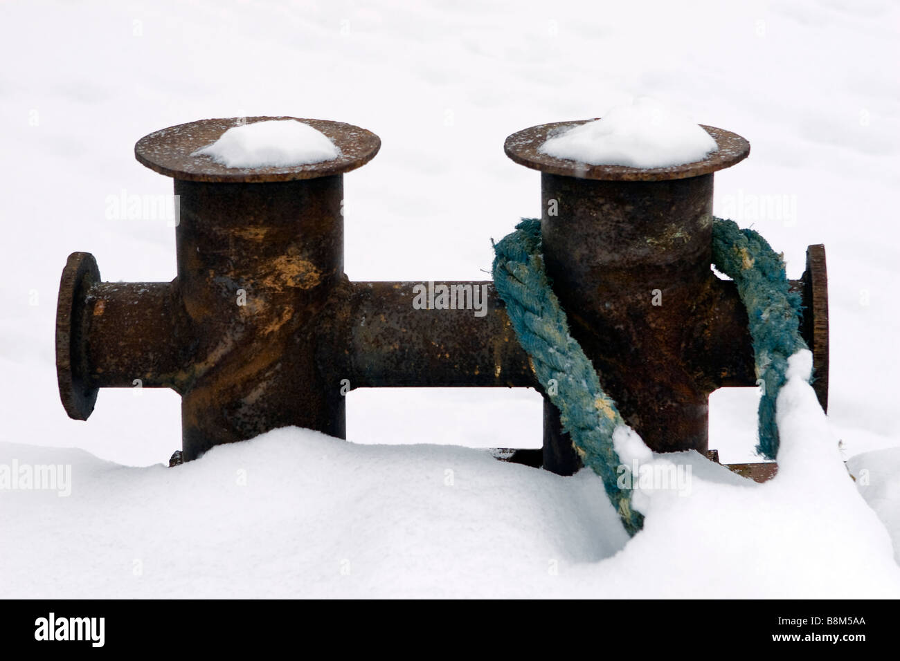 Unico bollard sul molo con cavo di traino fissata nel fuori stagione invernale. Foto Stock