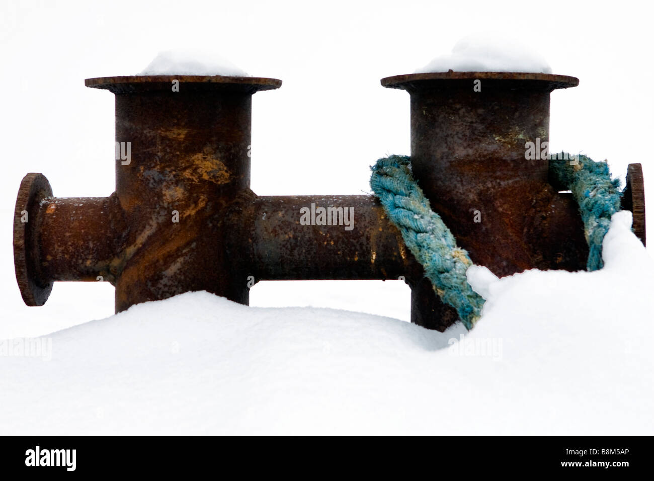 Unico bollard sul molo con cavo di traino fissata nel fuori stagione invernale. Foto Stock