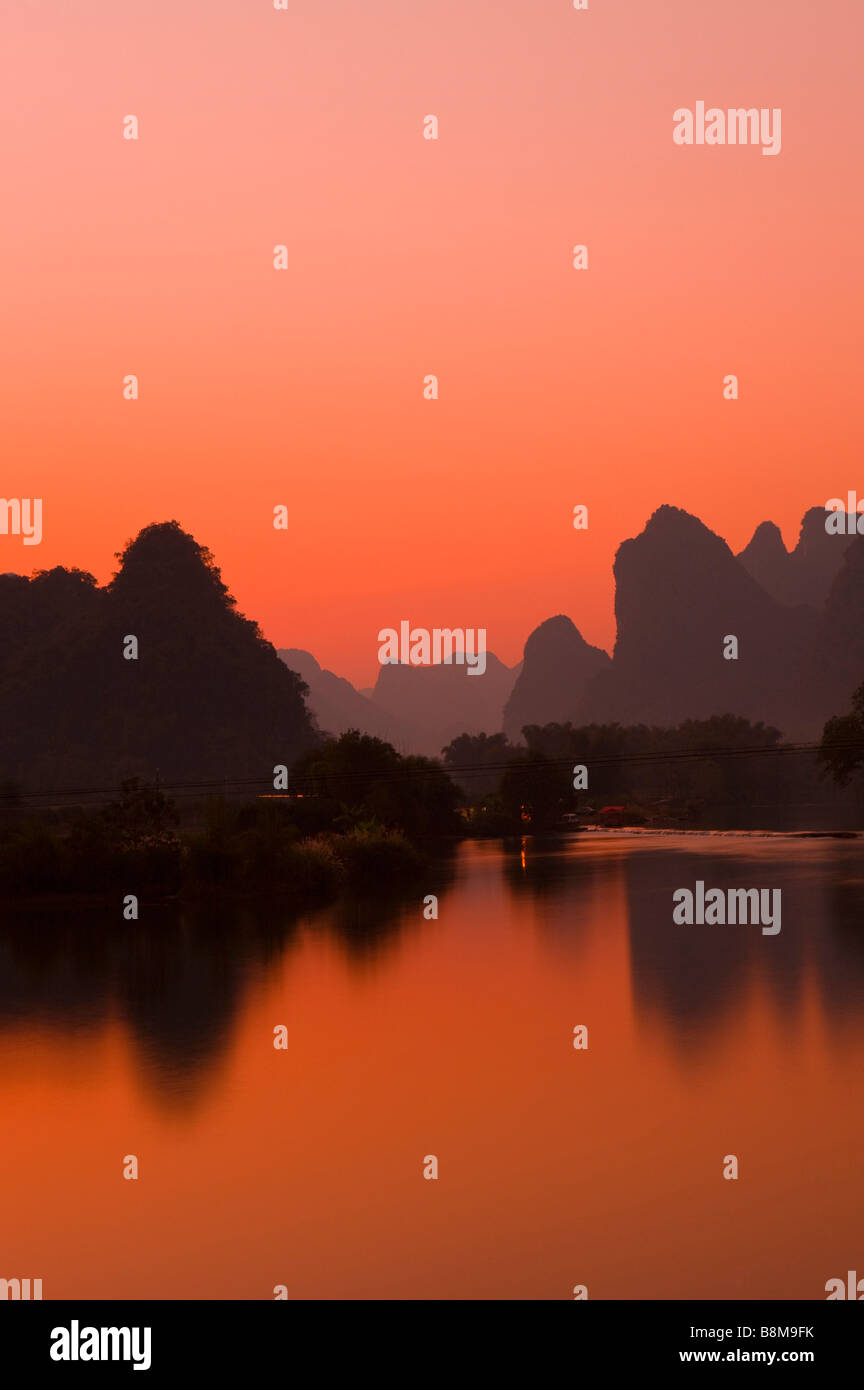 La Cina della provincia di Guangxi Guilin, Yangshuo Yulong River con montagne al tramonto Foto Stock