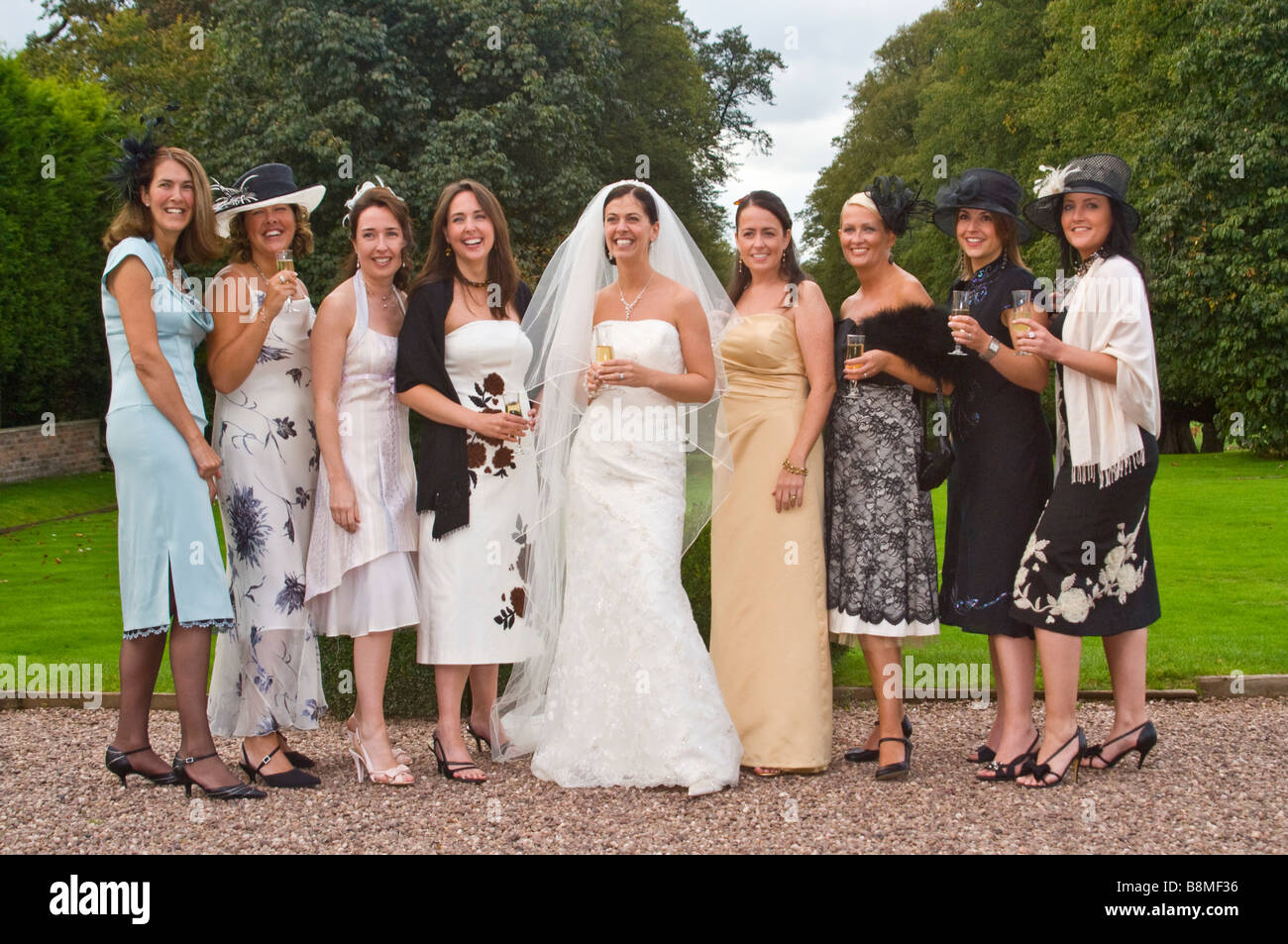 Orizzontale gruppo informale ritratto di una sposa tradizionale con tutte le sue amiche e familiari a un civile cerimonia di nozze Foto Stock