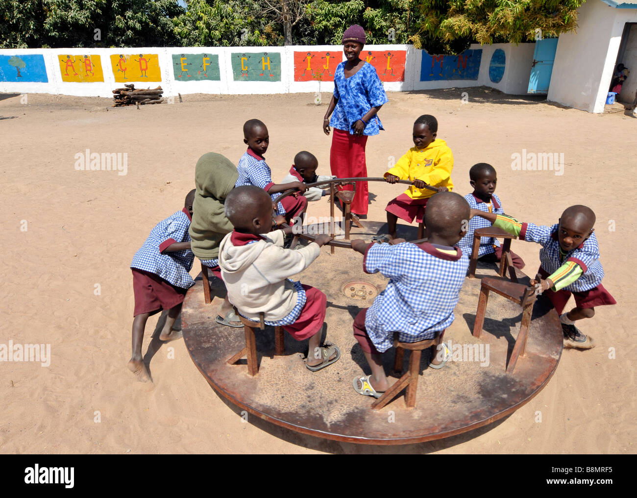 Scuola gambiana allievo a giocare nel parco giochi della scuola, Gambia, Africa occidentale Foto Stock