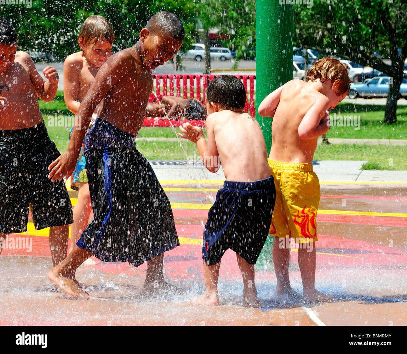 Cinque etnicamente diversi ragazzi giocare in un parco d'acqua. Oklahoma City, Oklahoma, Stati Uniti d'America. Foto Stock