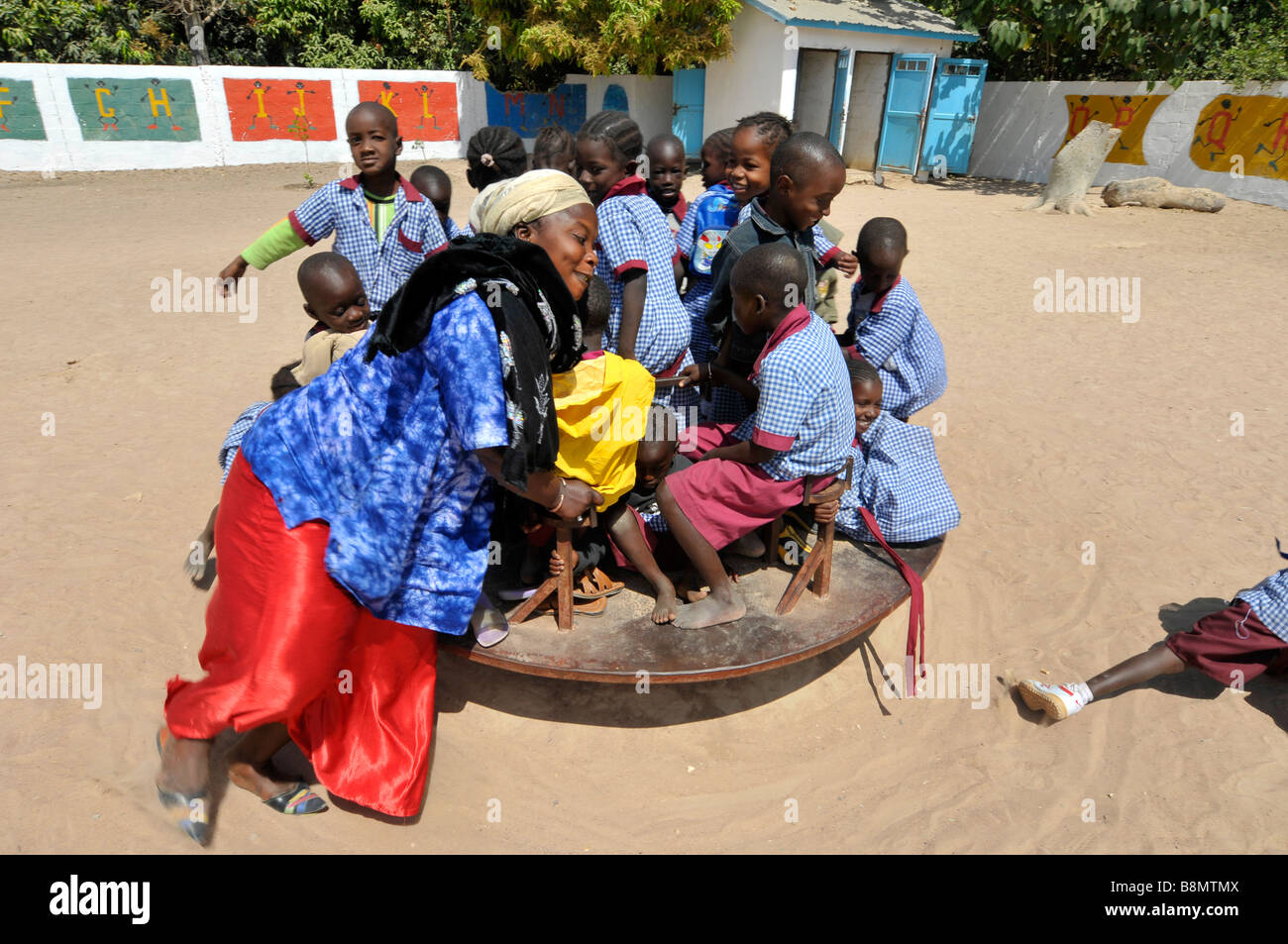 Scuola gambiana allievo a giocare nel parco giochi della scuola, Gambia, Africa occidentale Foto Stock