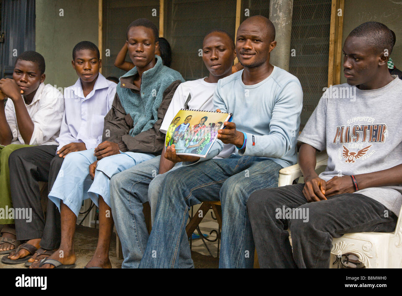 Un giovane uomo di Lagos, Nigeria, parla con il suo fuori-di-scuola i colleghi circa la prevenzione dell HIV. Foto Stock