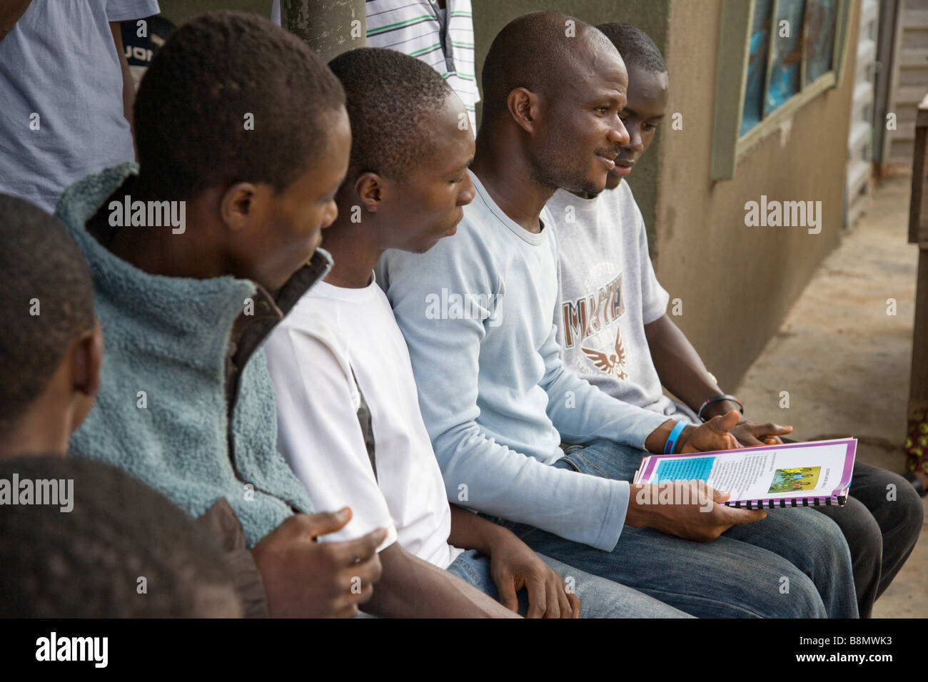 Un giovane uomo di Lagos, Nigeria, parla con il suo fuori-di-scuola i colleghi circa la prevenzione dell HIV. Foto Stock