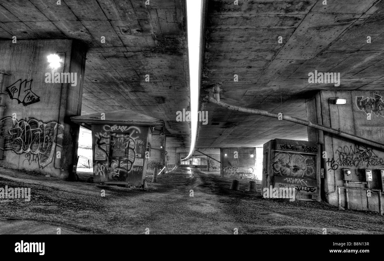 Fotografia in bianco e nero di graffiti in un sottopasso urbano parcheggio, inquietanti, spaventoso, di criminalità e di arte urbana convergono. Foto Stock