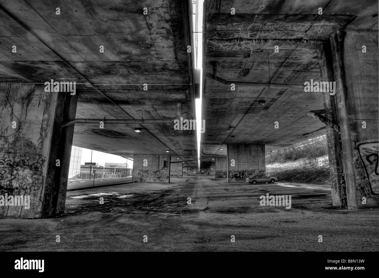 Fotografia in bianco e nero di graffiti in un sottopasso urbano parcheggio, inquietanti, spaventoso, di criminalità e di arte urbana convergono. Foto Stock