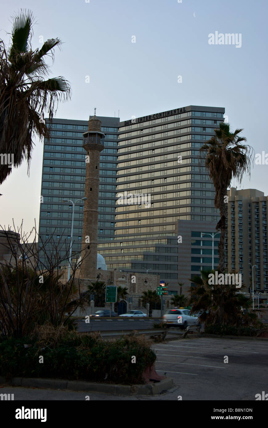 Sunrise over Hassan Bek moschea con imponente minareto sul lungomare con il David Intercontinental Hotel dietro Foto Stock