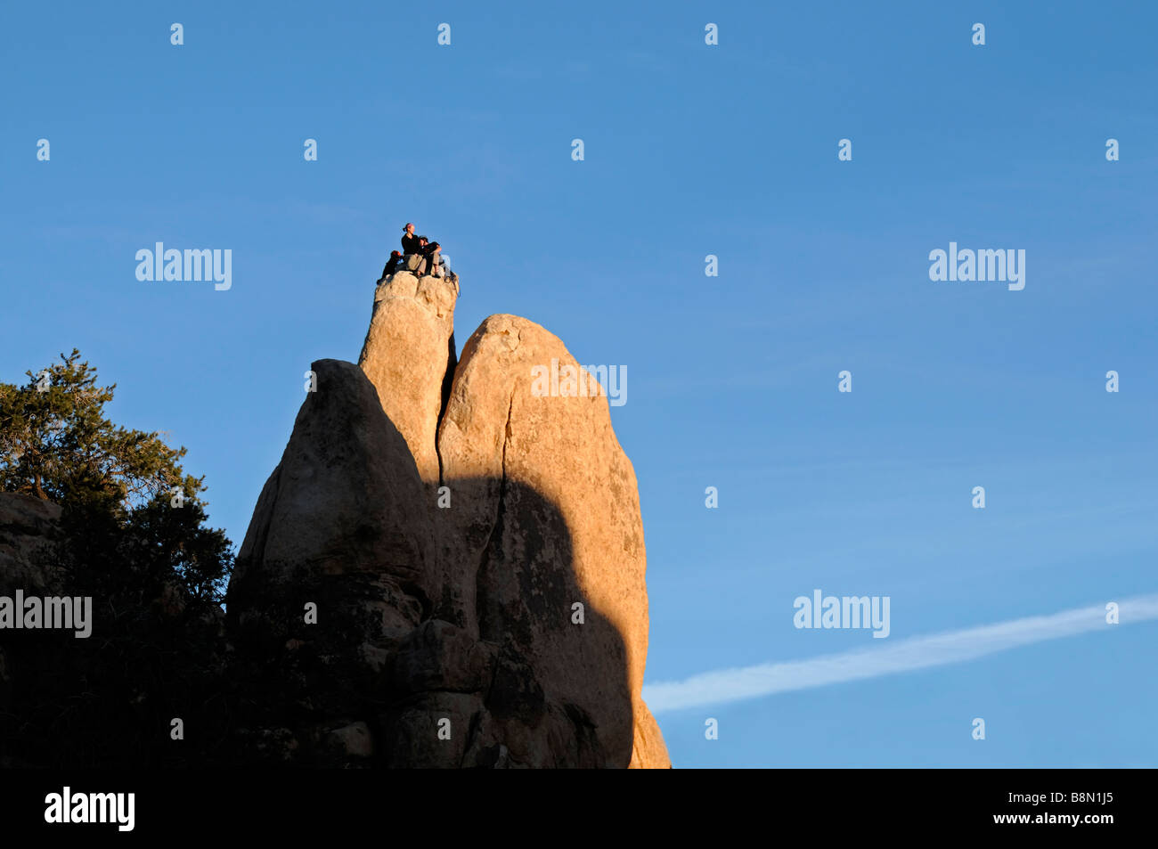 Tre arrampicatori l uomo e la donna sempre pronto a scendere dalla parte superiore di un pinnacolo di roccia Hidden Valley Joshua Tree National Park Foto Stock