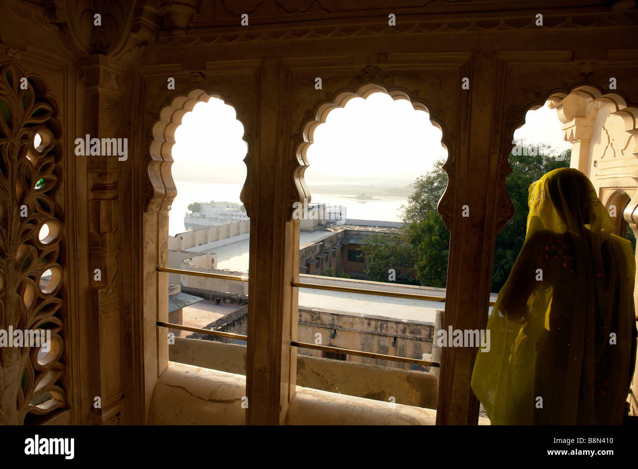 Donna indiana in abito tradizionale in corrispondenza di una finestra con balcone presso il palazzo della città Foto Stock
