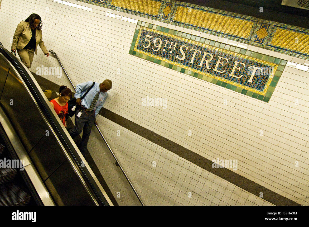 Pendolari su una scala mobile a 59th Street Subway Foto Stock