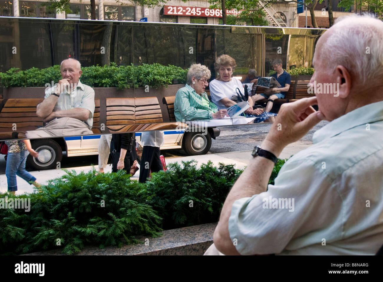 Scena urbana con gente seduta sulle panchine Foto Stock