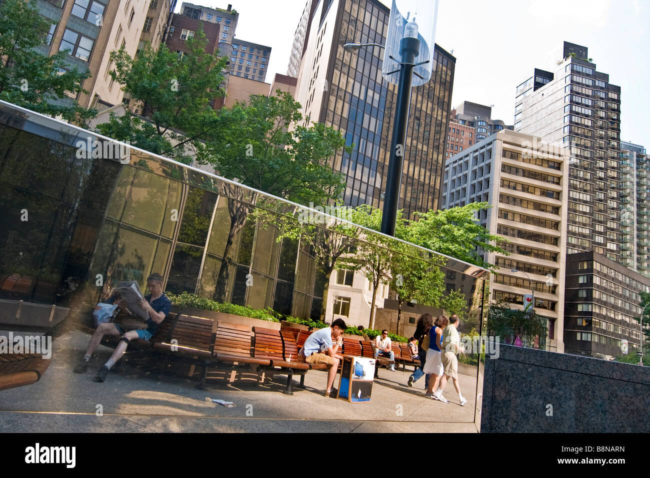 Scena urbana con gente seduta sulle panchine Foto Stock