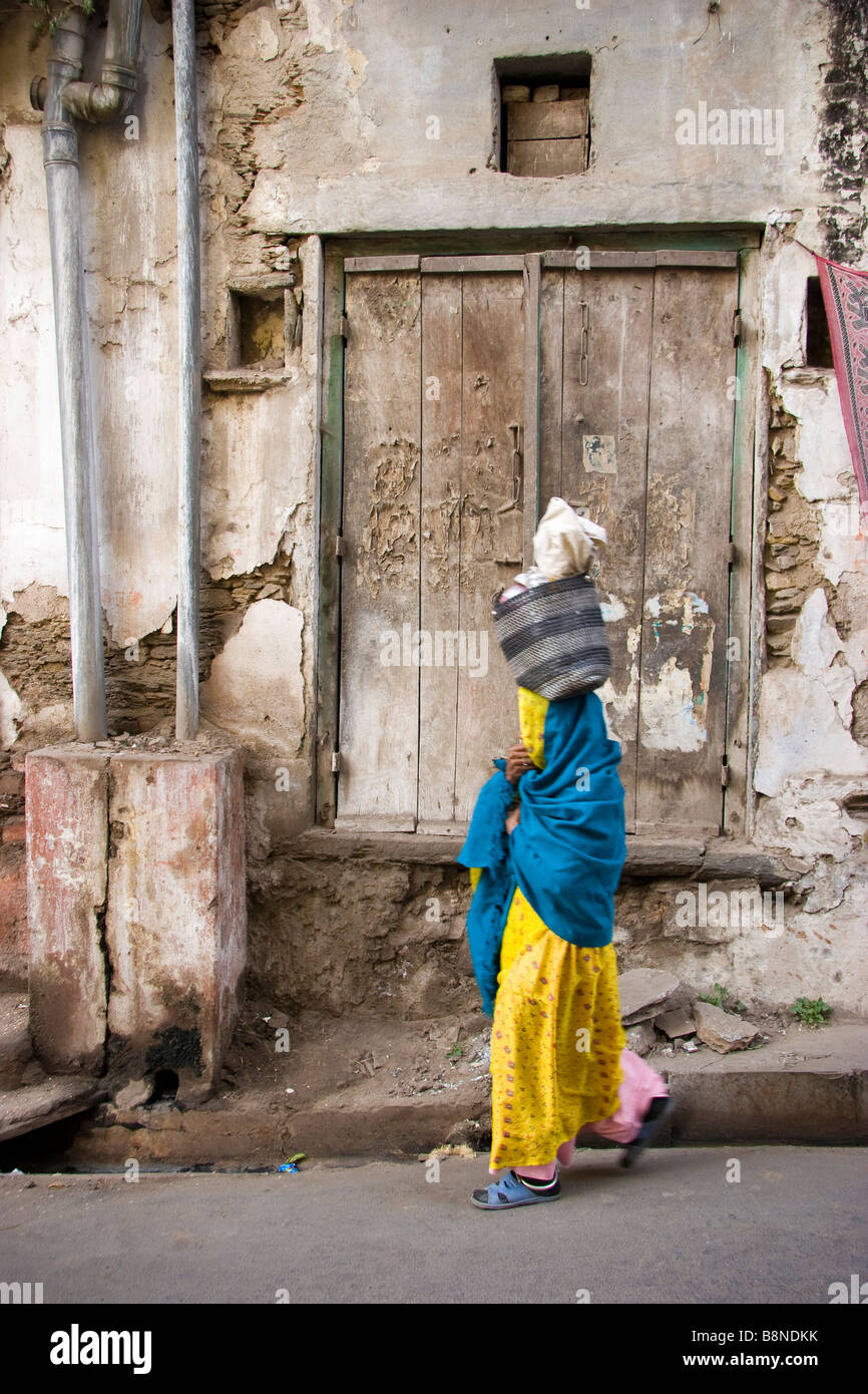 Locale indiana donna cammina giù street Udaipur Rajasthan in India Foto Stock
