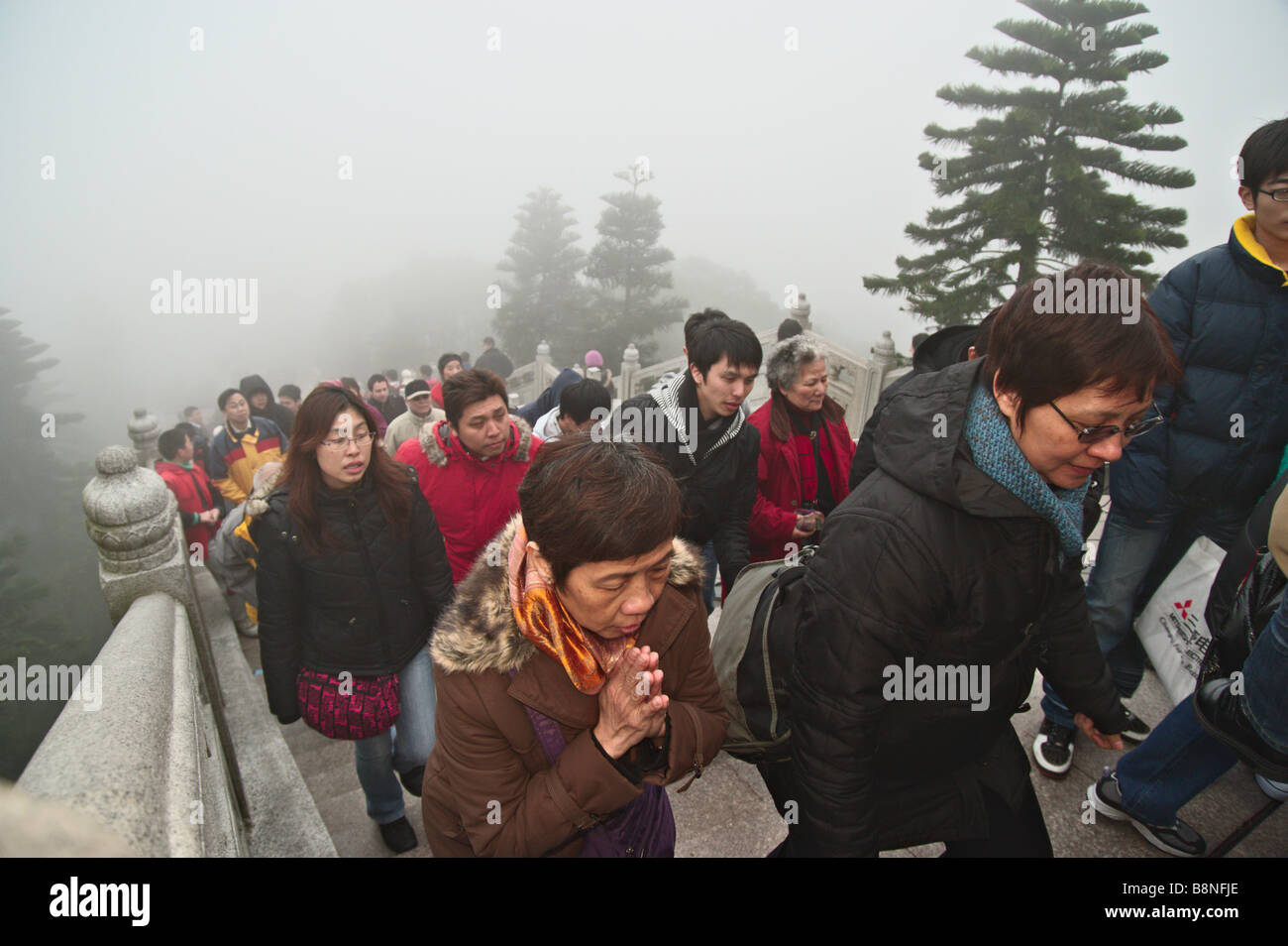 I visitatori a salire la 268 passi per il Big Buddha a Lantau Hong Kong su una nebbia primo giorno del nuovo anno lunare 2009 Foto Stock