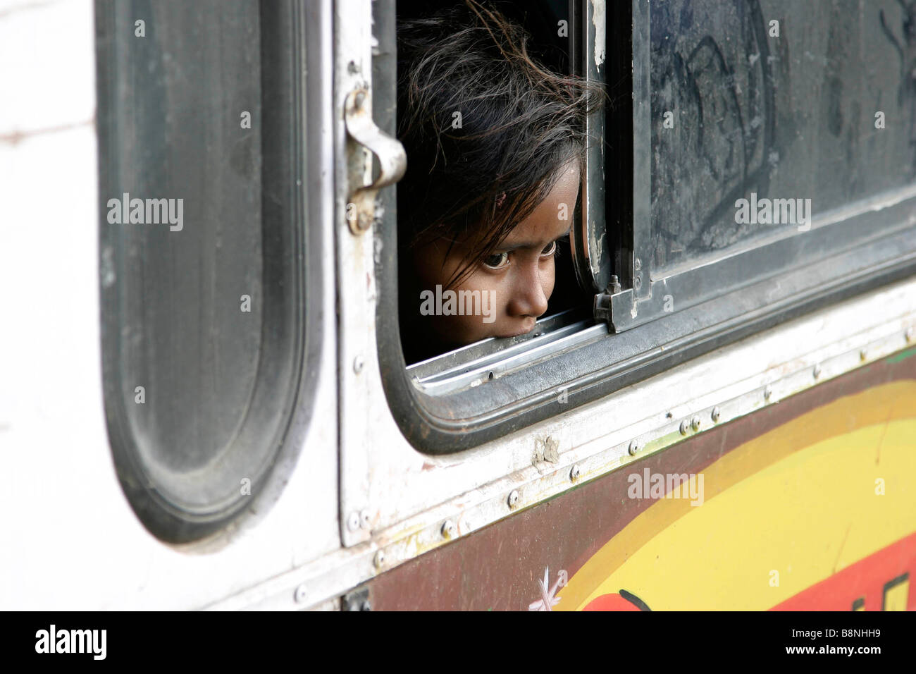 Giovane ragazza guarda fuori da una finestra di bus in India Foto Stock