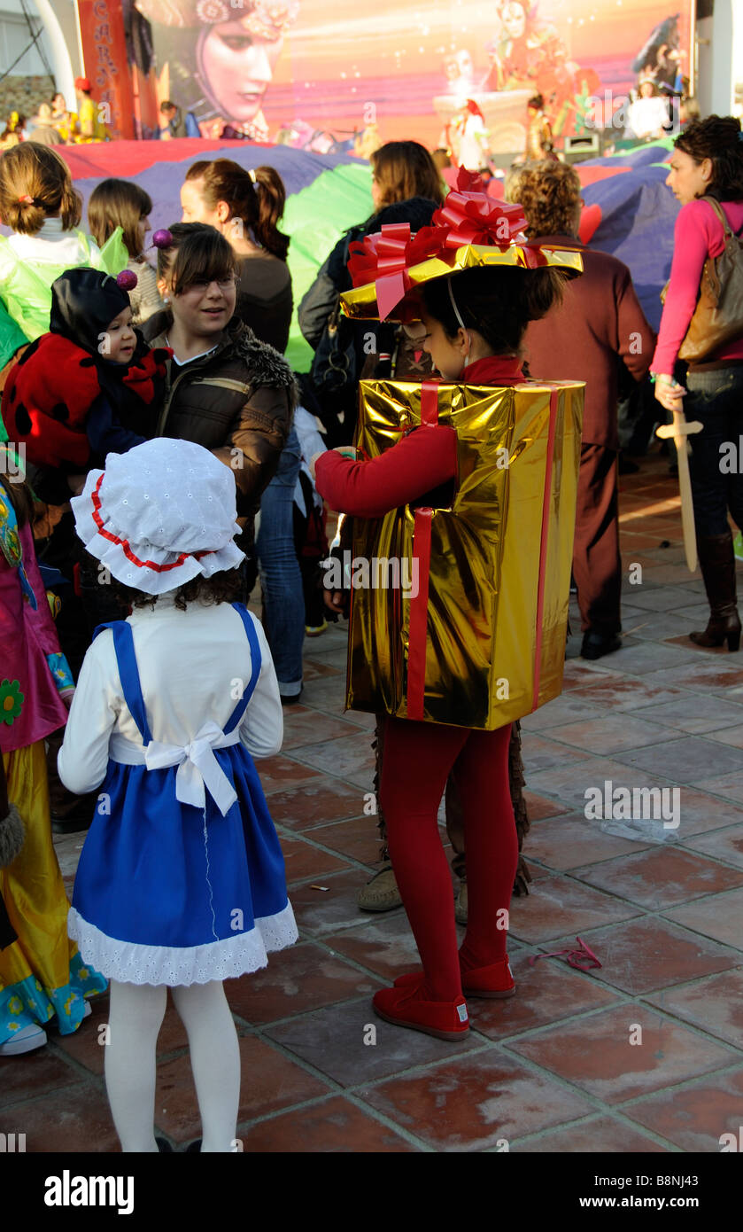 Bambina abiti fantasiosi come un pacchetto gold presente avvolto in nastro rosso. Un concorrente di carnevale annuale a La Herradura Foto Stock