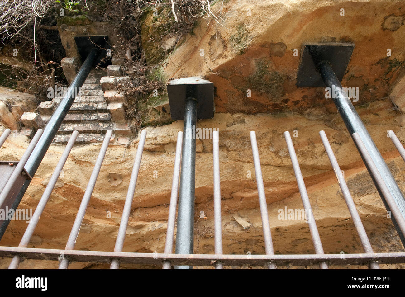 Tre metalli puntelli di supporto tenendo su una roccia sotto il castello di Nottingham, Inghilterra,'Gran Bretagna" Foto Stock