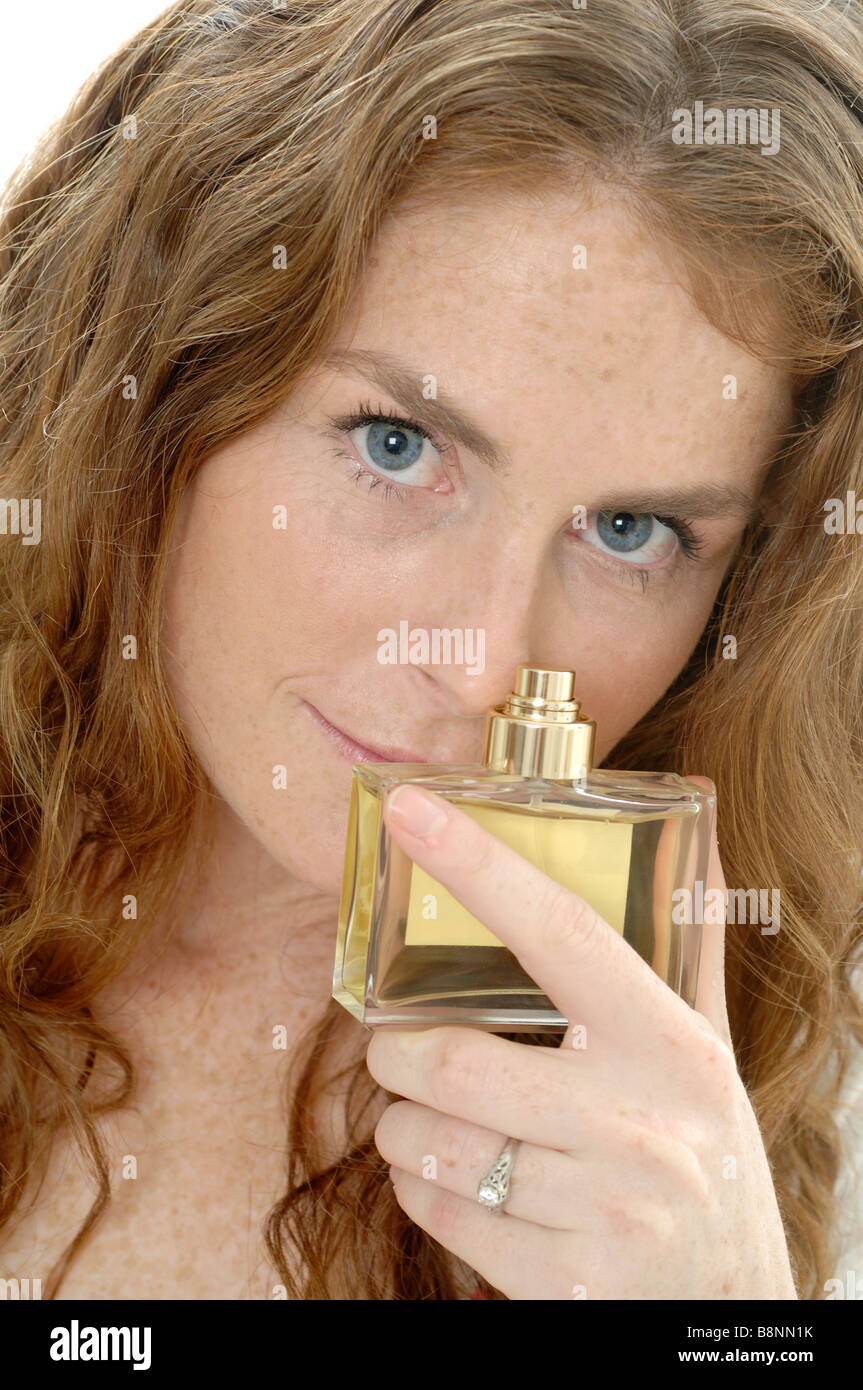 Rothaarige Frau mit Parfümflasche Foto Stock