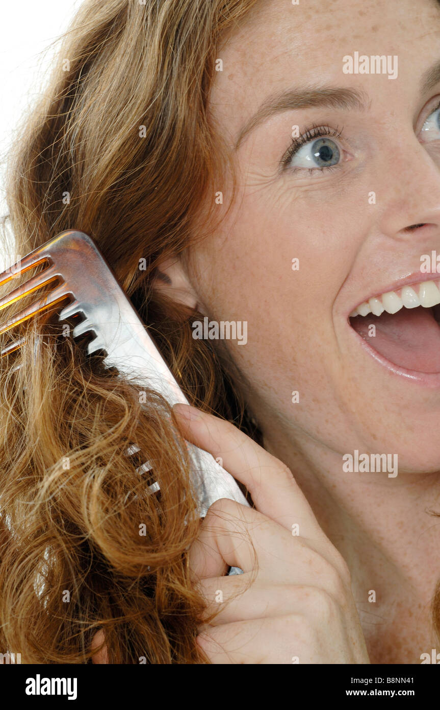 Donna pettinare i capelli Foto Stock