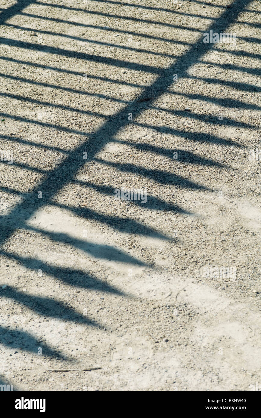 Ombra di ferro battuto recinzione sulla ghiaia Foto Stock