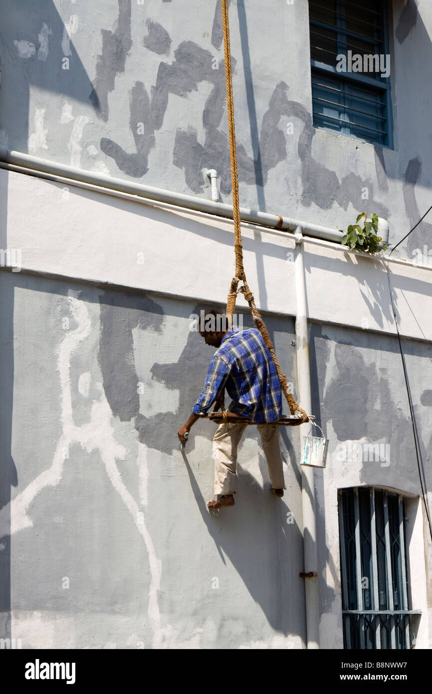 India Pondicherry il territorio dell' Unione cittadina francese uomo sospeso su bosuns chair riverniciatura house Foto Stock