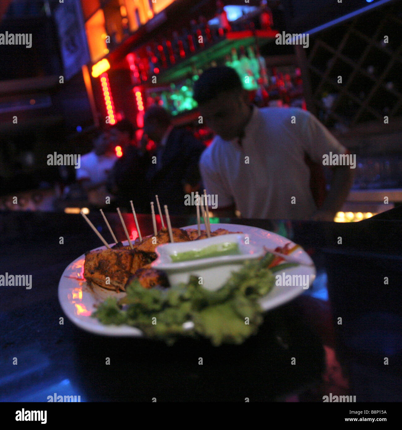 Una piastra di snack sorge su un banco di bar in un night club di Chandigarh in India Foto Stock