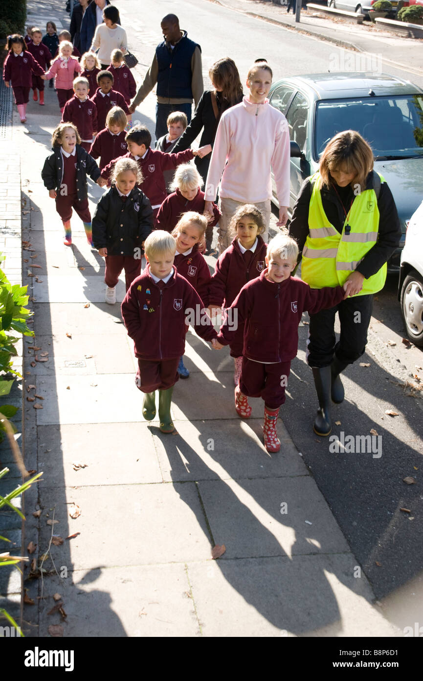 Scuola junior bambini su supervisionato a piedi con gli insegnanti Foto Stock