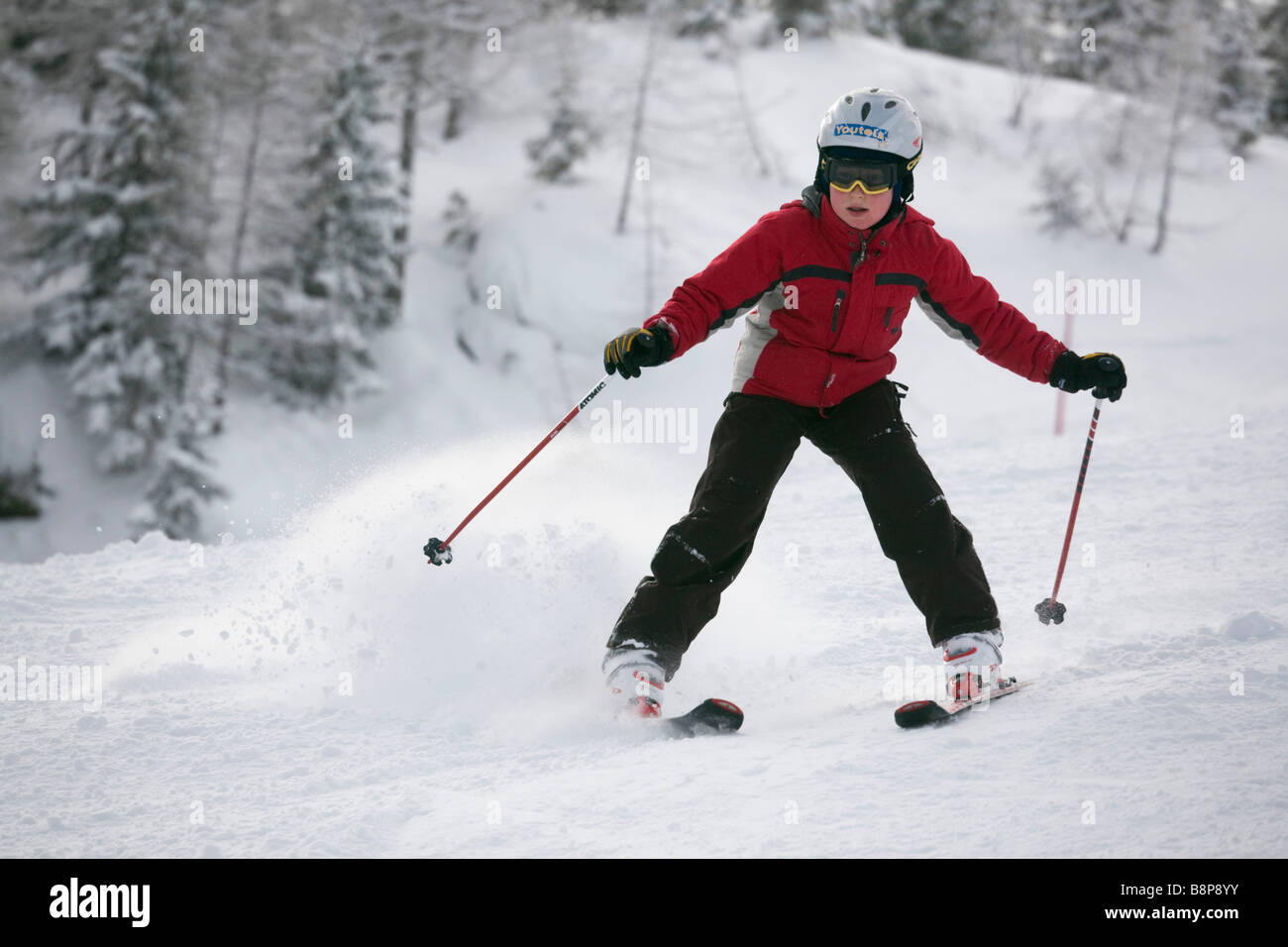 Giovane debuttante sciatore facendo ruotare lo spazzaneve in discesa sugli sci con neve fresca sulla pista da sci piste da sci nelle Alpi austriache Austria Europa Foto Stock