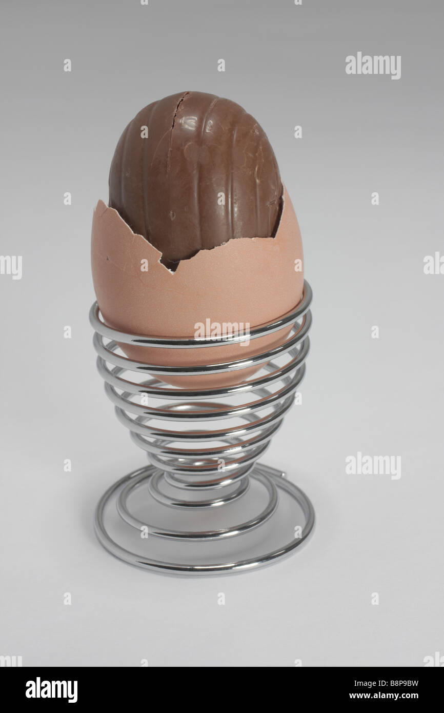 Uovo di cioccolato all'interno di un vero e proprio uovo in un moderno cromo uovo cup Foto Stock