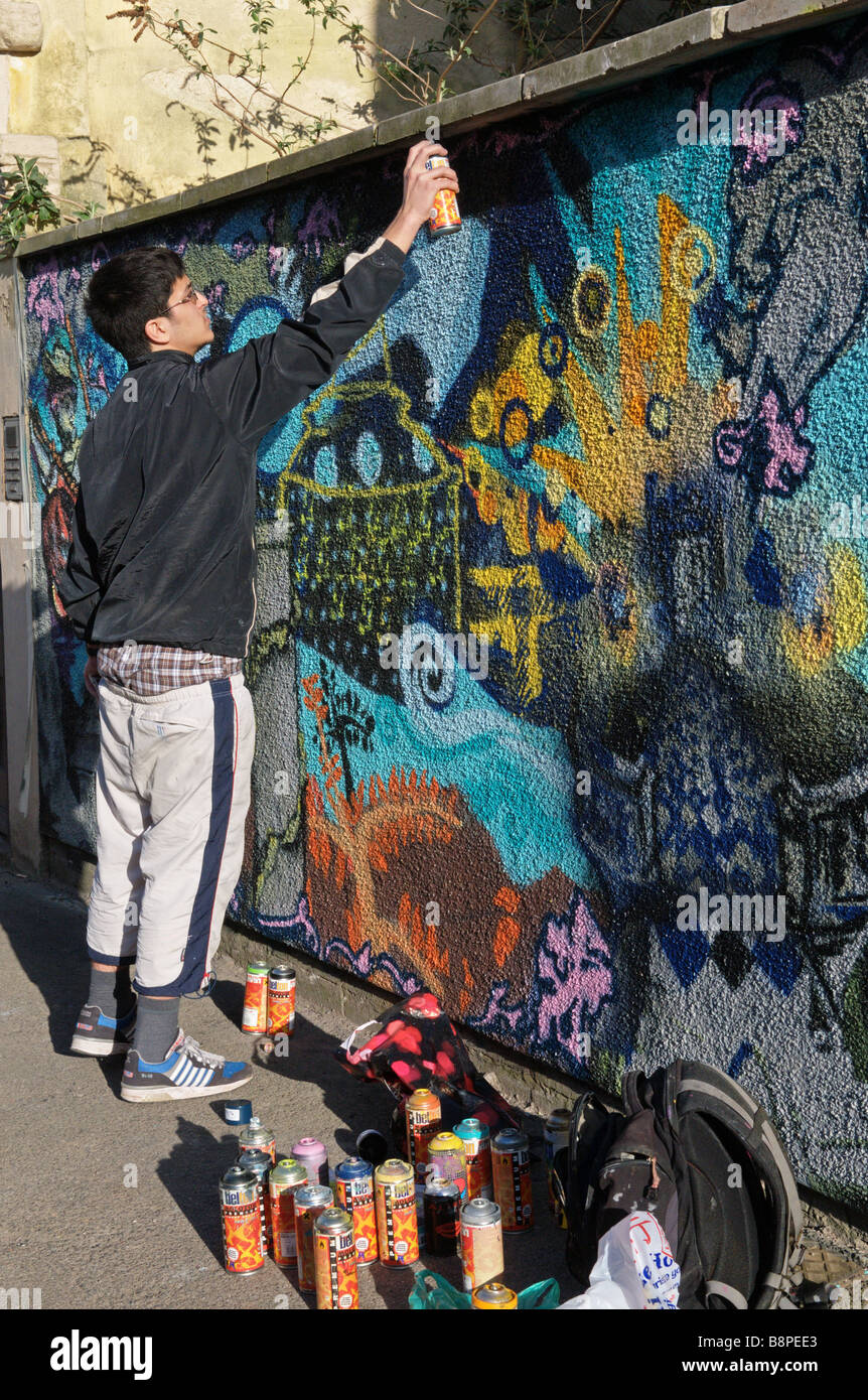 Artista di graffiti parete verniciatura murall Stokes Croft area di Bristol Inghilterra Foto Stock