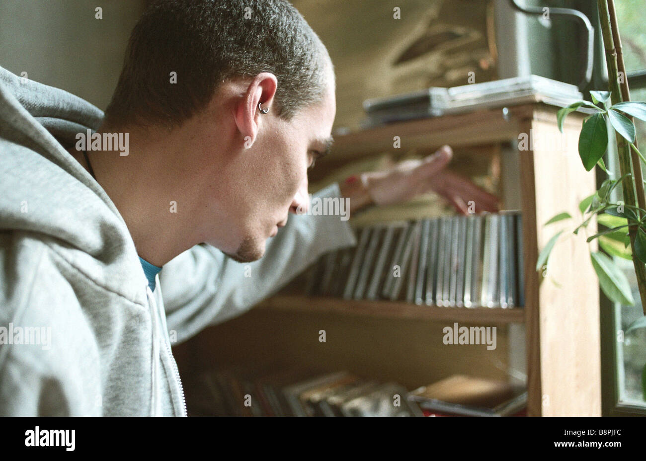 Giovane uomo selezione di CD da collezione sul ripiano Foto Stock