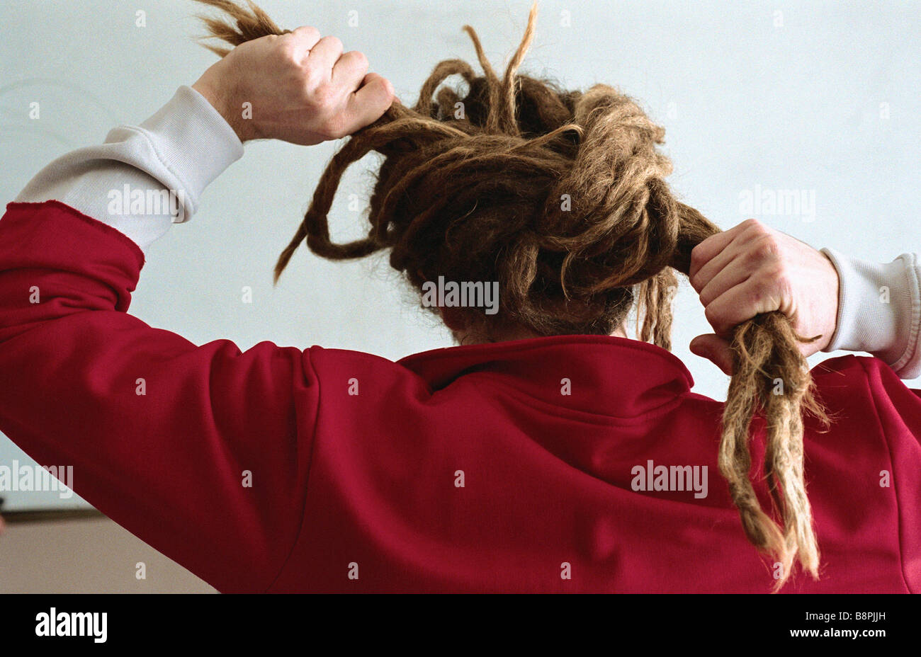 Uomo con lunghi dreadlocks, legatura in bun, vista posteriore Foto Stock