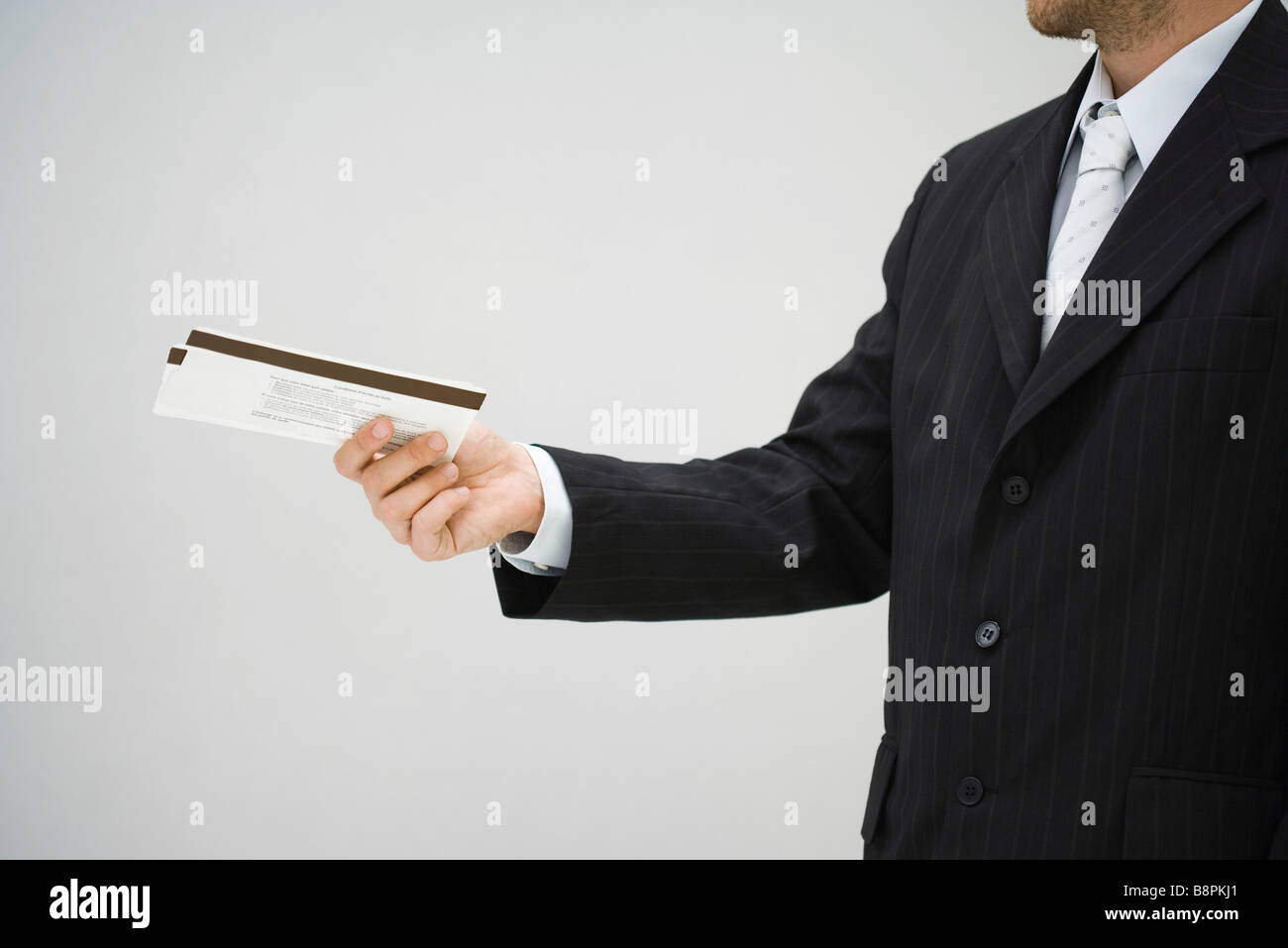 Uomo in tuta tenendo fuori i biglietti, vista laterale Foto Stock