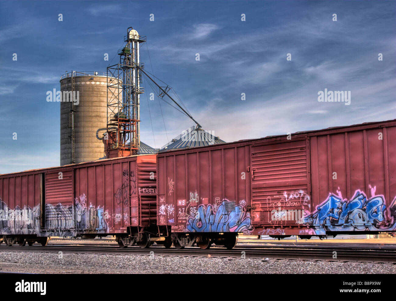 Immagine hdr di colorati graffiti coperto treno merci le automobili con un elevatore della granella Foto Stock