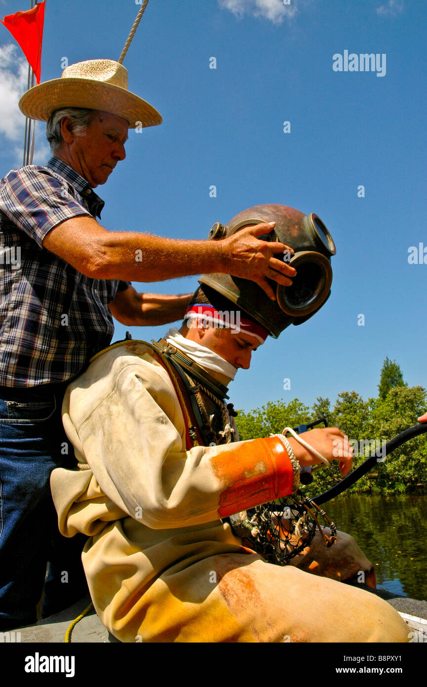 Tarpon Springs Florida subacqueo in spugna di elmetto deep sea diver suit preparando per immersione la predisposizione di metallo casco in ottone Foto Stock
