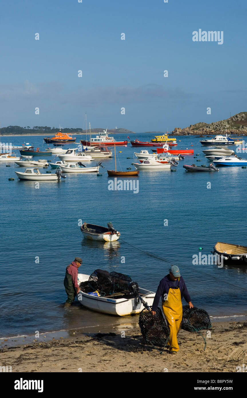 Due pescatori scaricano i loro vasi sulla spiaggia di Hugh Town. St Mary's. Isole Scilly. La Cornovaglia. In Inghilterra. Regno Unito Foto Stock