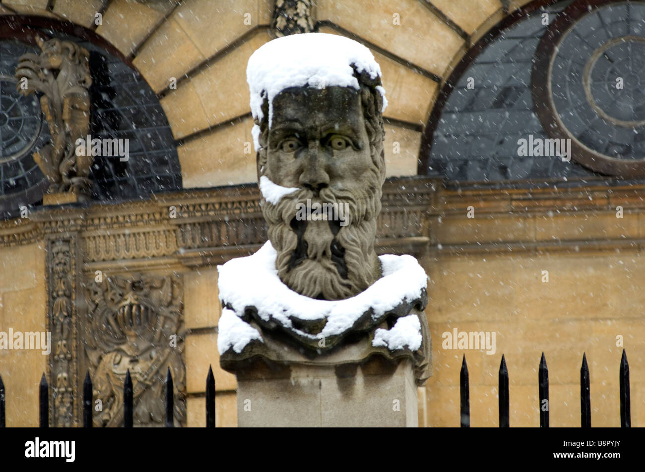 Una statua al di fuori del Sheldonian Theatre coperto di neve dopo una tempesta all'Università di Oxford nel Regno Unito Foto Stock