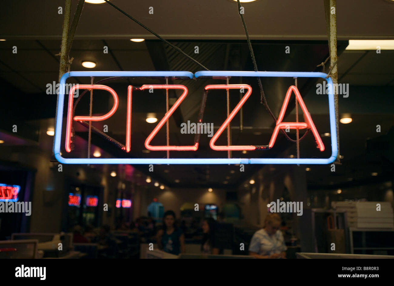 Una pizza insegna al neon è illuminata in un ristorante. Foto Stock