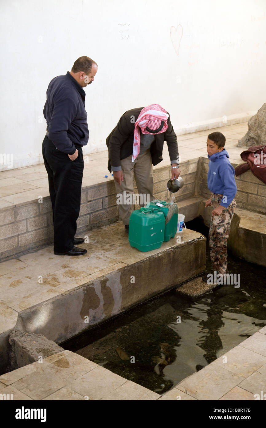 La gente a prendere l'acqua dalla molla di Mosè, una delle molle portato via per i figli d'Israele, Giordania Foto Stock