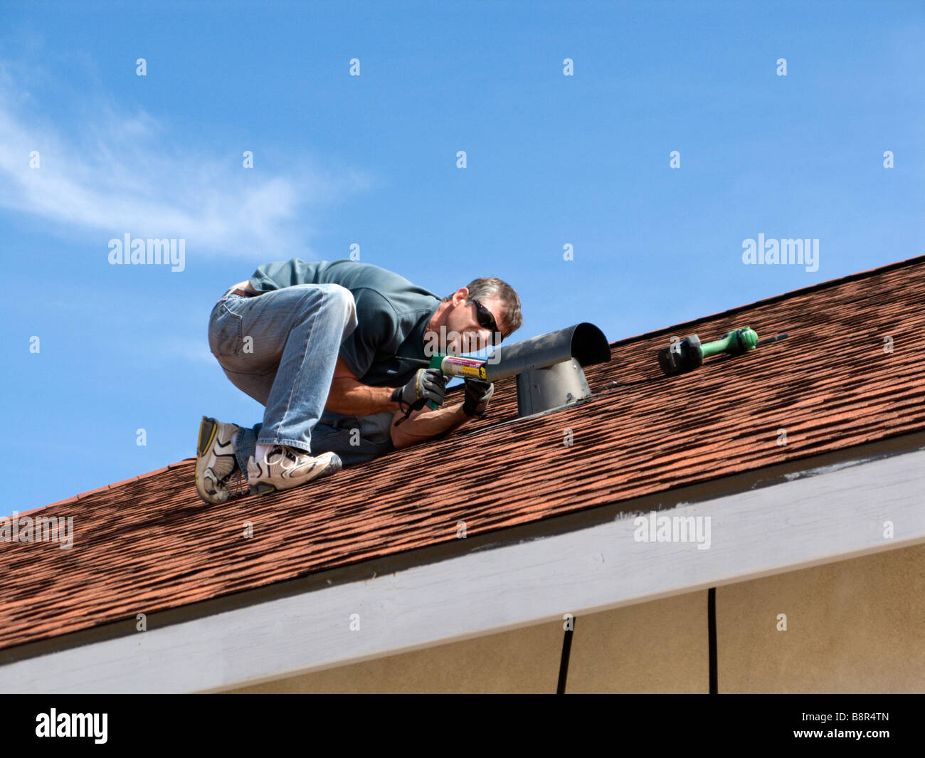 Uomo al lavoro su tetto Foto Stock