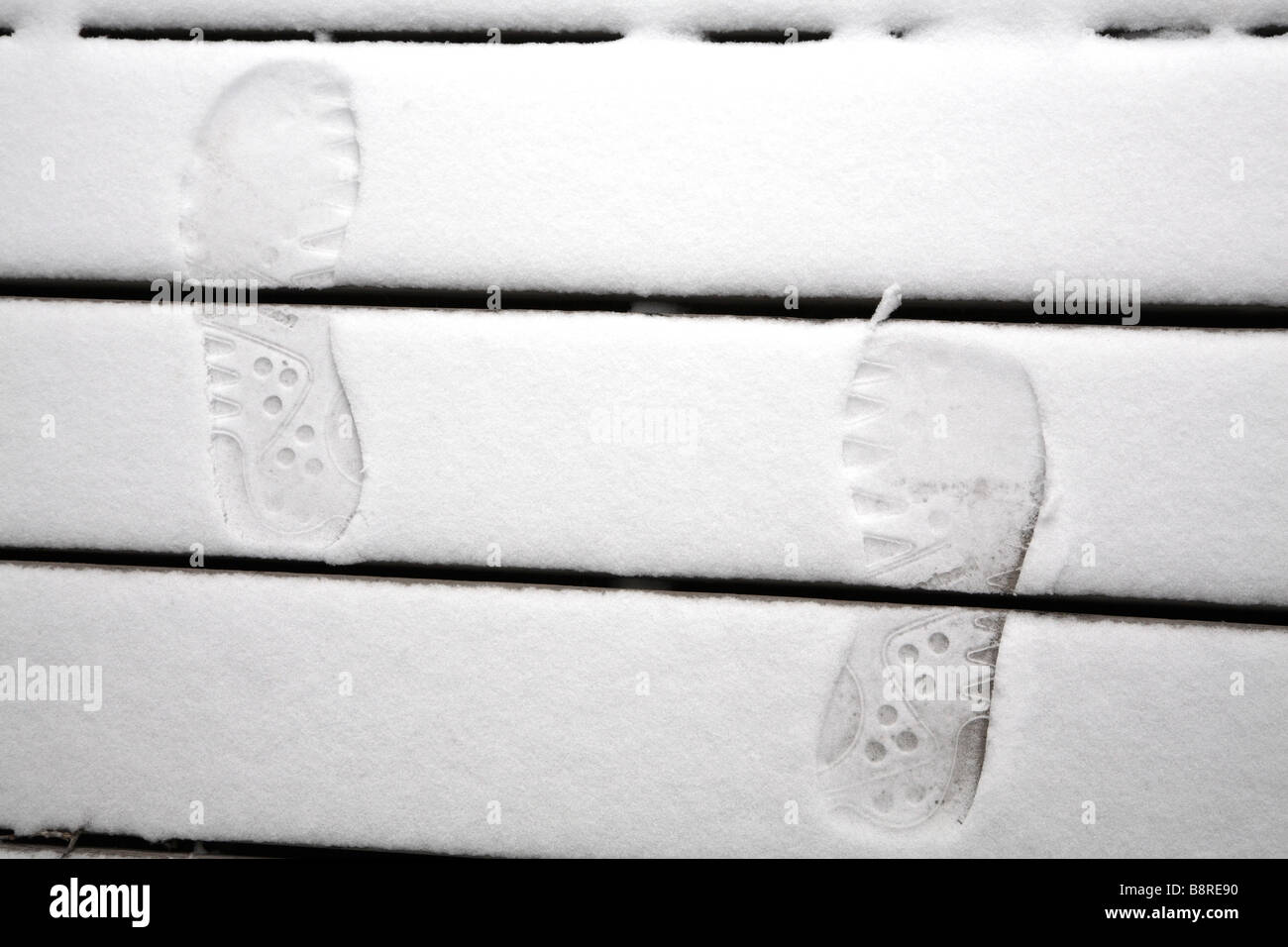 Orme nella neve sui gradini in legno. Foto Stock