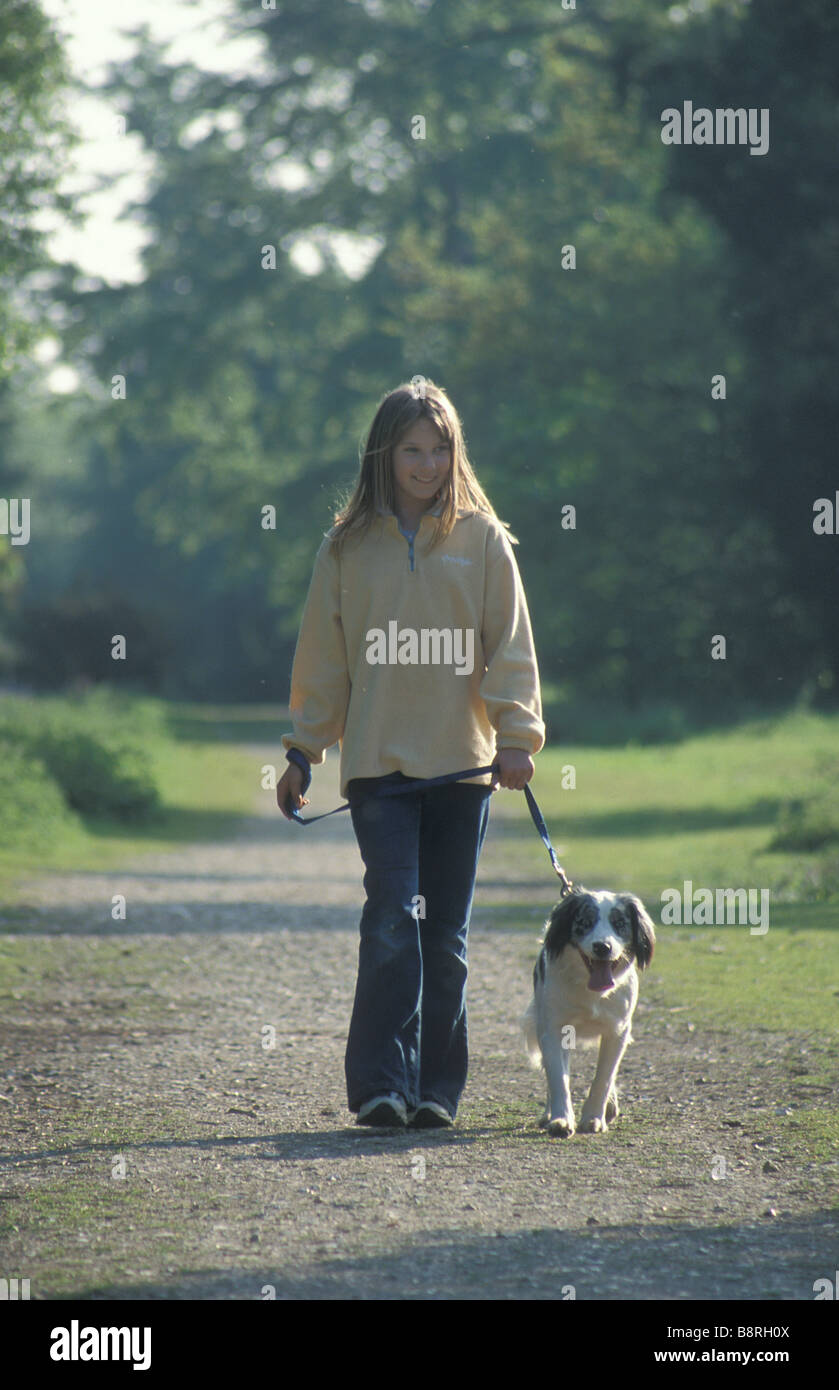 Giovane ragazza camminare mongrel cucciolo sul percorso del bosco Foto Stock