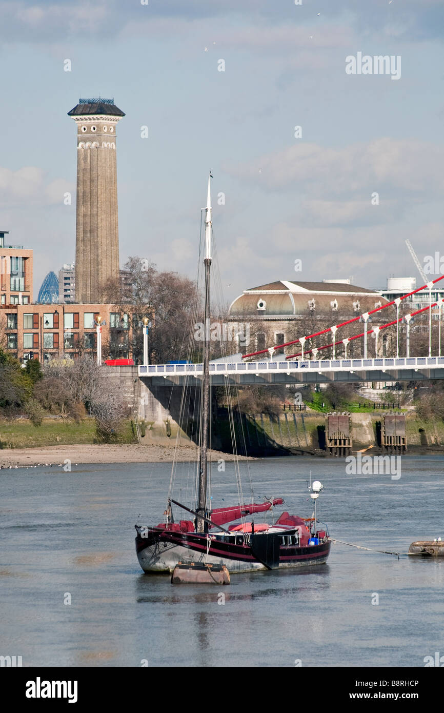 Barca sul Tamigi con Chelsea Bridge e torre shot in background. London, England, Regno Unito Foto Stock
