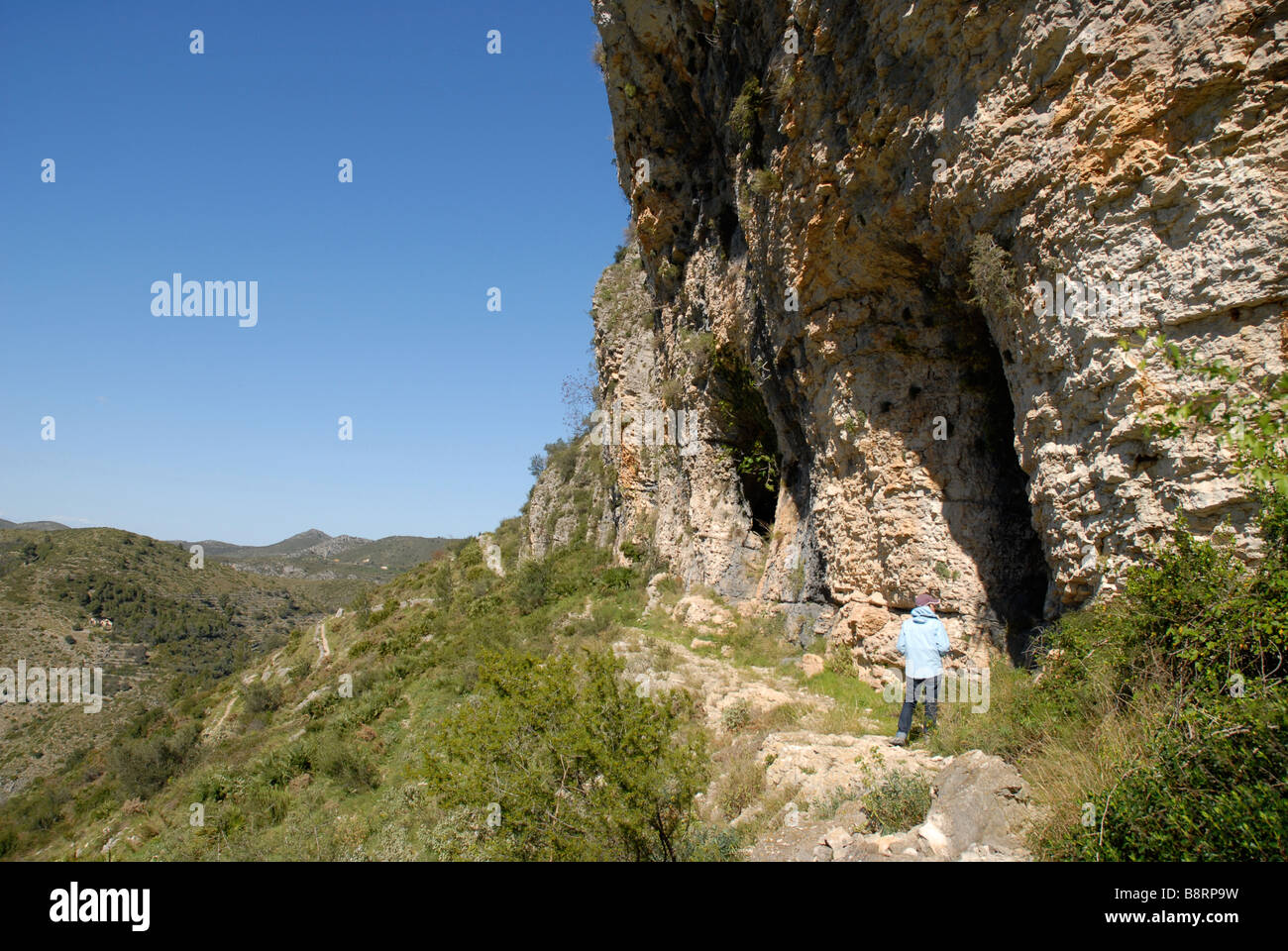Donna escursionista esplorare grotte off mozarabo trail, Vall de Laguart, Benimaurell, Provincia di Alicante, Comunidad Valenciana, Spagna Foto Stock