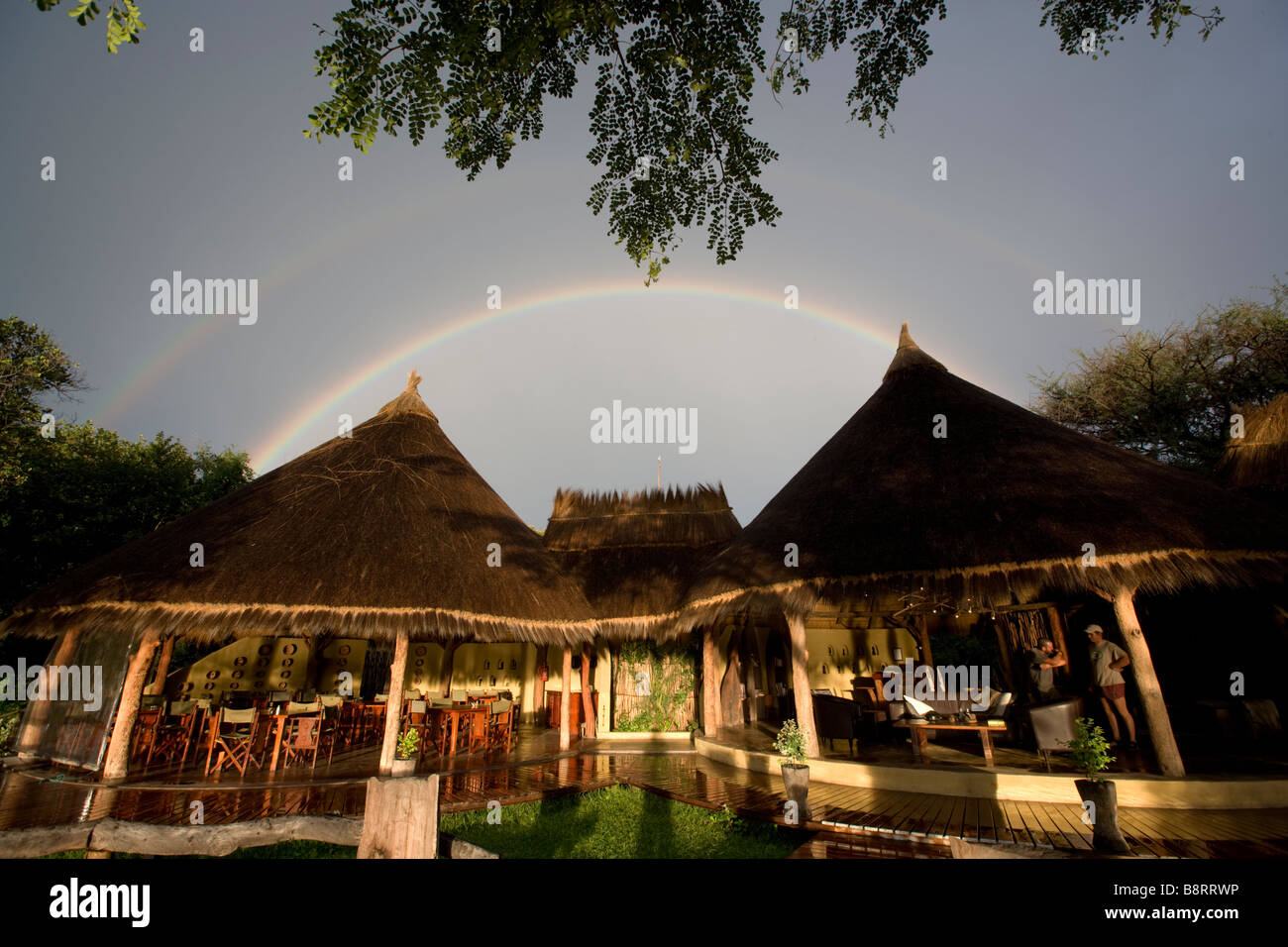 Africa Namibia impostazione luci Sun Camp Kwando lungo il fiume Kwando nel Caprivi Strip sotto arcobaleno passando dalla tempesta di pioggia Foto Stock