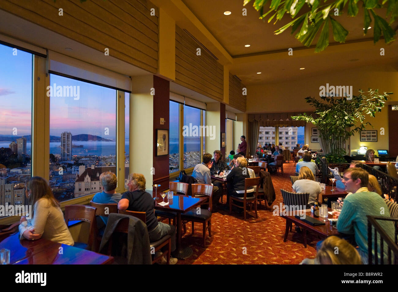 San Francisco, California, Stati Uniti d'America. Parte superiore del marchio bar sul tetto al tramonto, Intercontinental Mark Hopkins Hotel di Nob Hill. Foto Stock