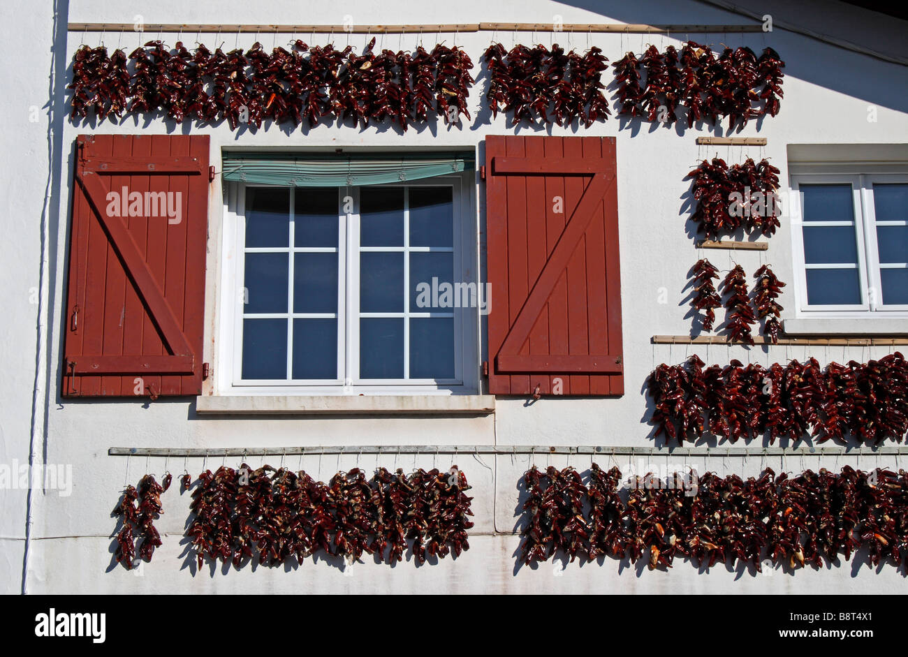Peperoni rossi appesi per asciugare in Espelette, nel Pays Basque regione della Francia. Foto Stock