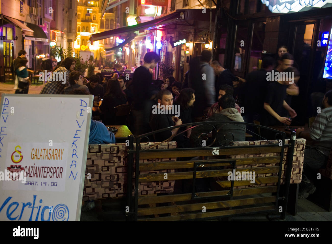 Gioventù turca partying in un cafè sul marciapiede in Istanbuls quartiere Taksim. Foto Stock